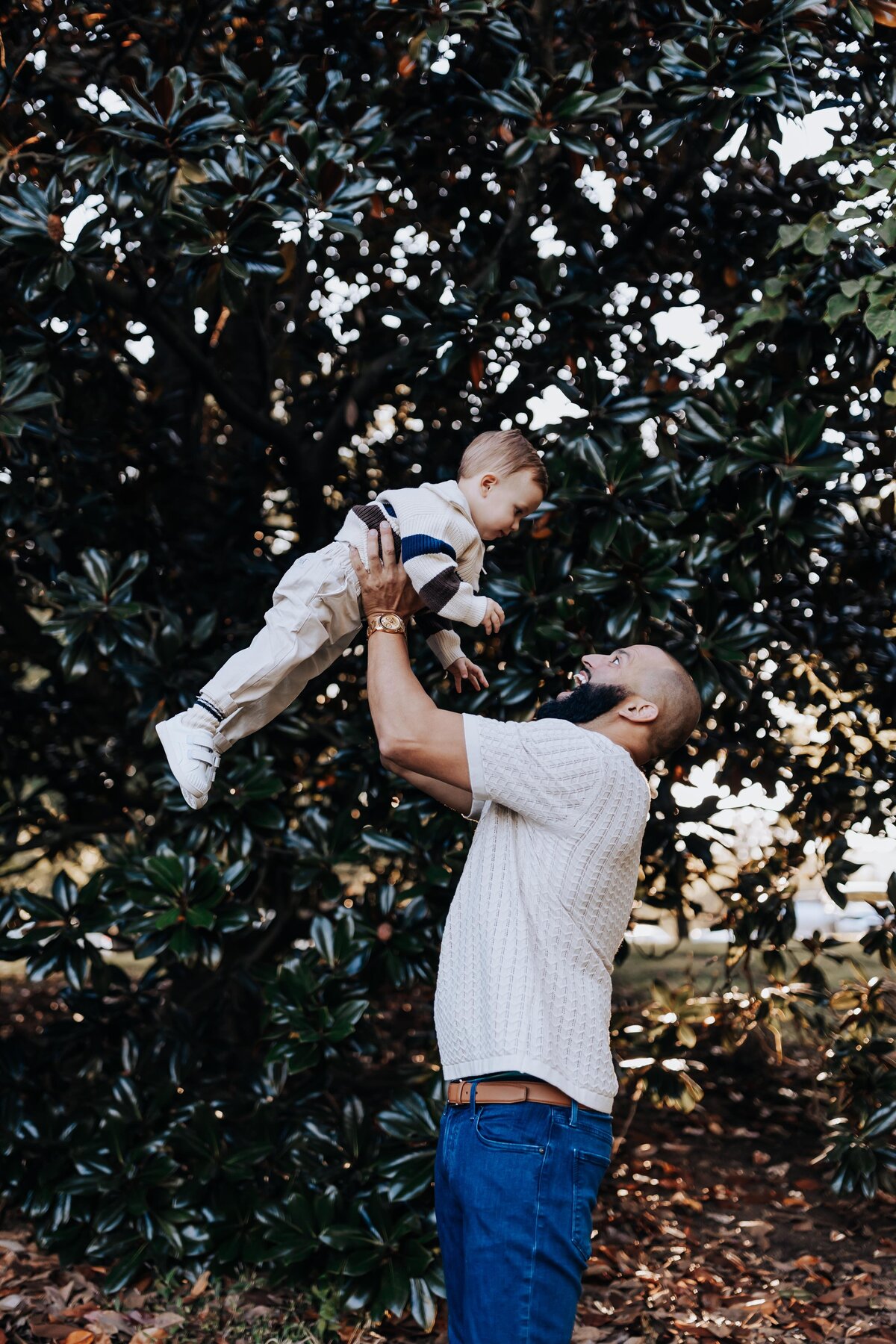 Nashville family photographers capture father lifting child during outdoor photos