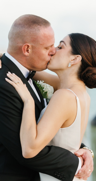 Bride and groom share a romantic kiss. Captured by Claudia Amalia, a wedding photographer in Islamorada