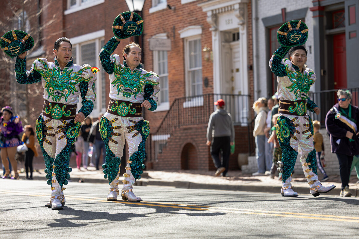 Three men dancing with their hat, during a local event parade. featuring a local dance group in the alexandria, va area. 