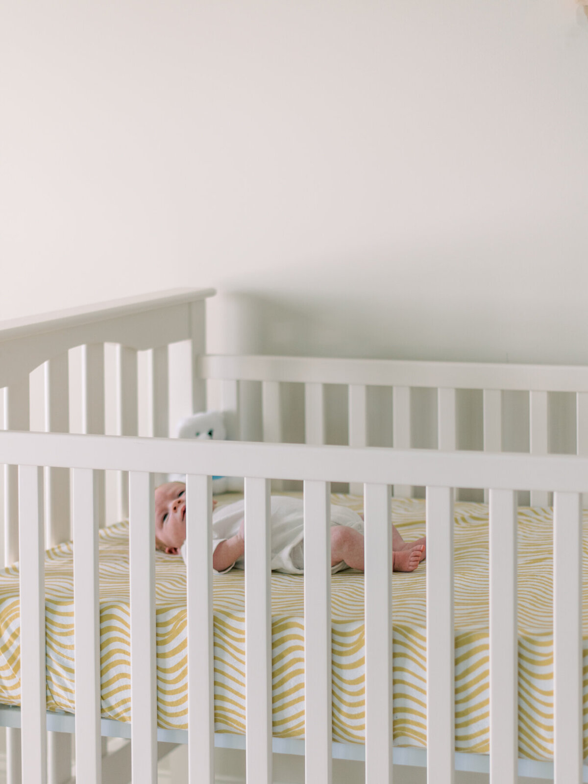 baby laying in white crib by Richmond Newborn Photographer Shelby