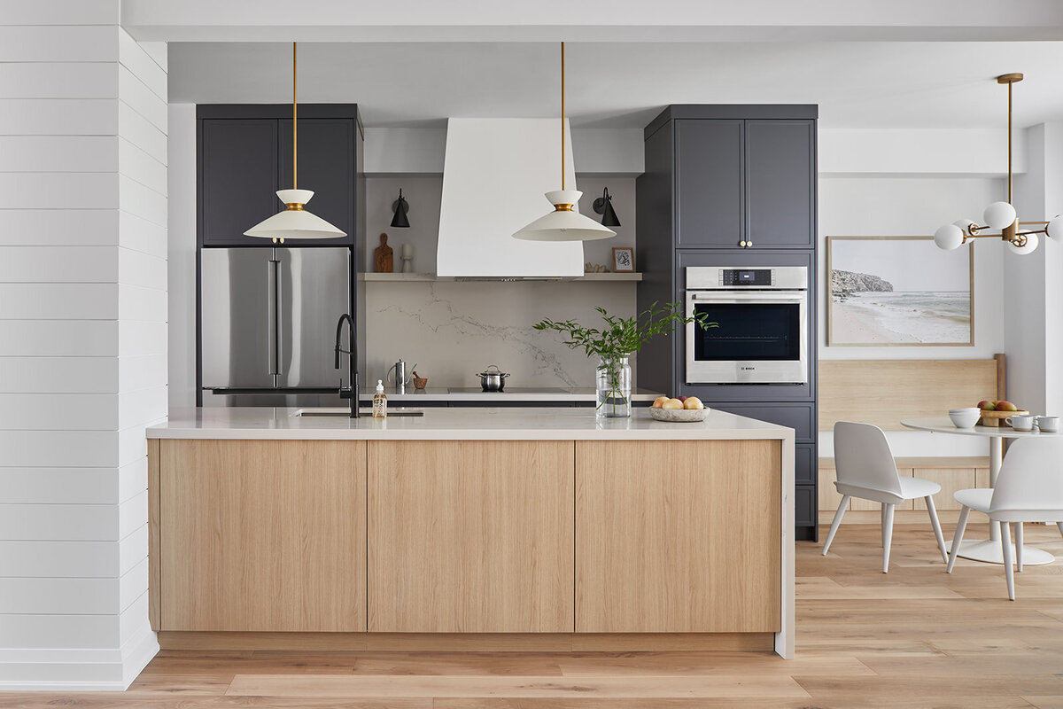 Kitchen with white and grey subway tiles, marble counter top, solid white cabinets, and gold hardware