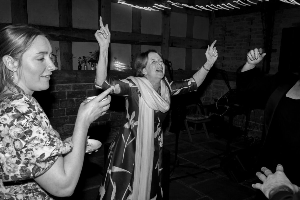 Wedding guests dance  in the Wool Barn at Frampton Court Estate, Gloucestershire