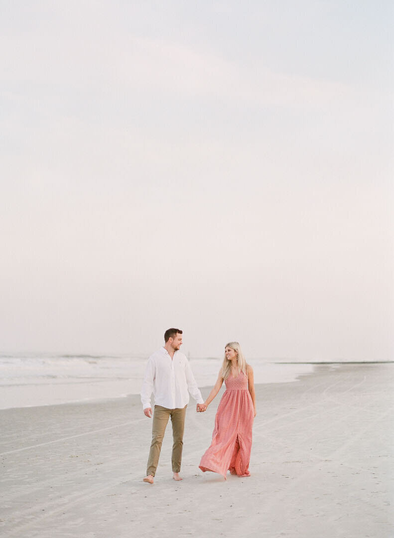 Couple Holding Hands Walking on Beach Photo