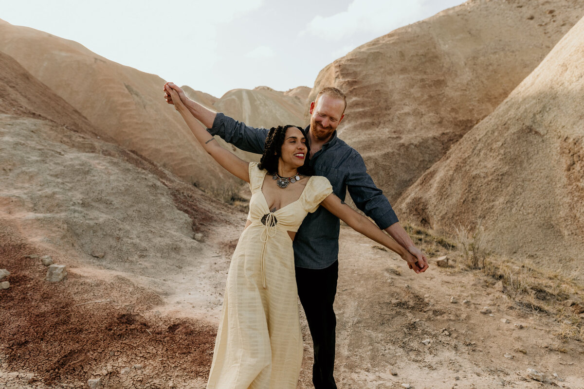 couple playfully walking among colorful rocks in New Mexico