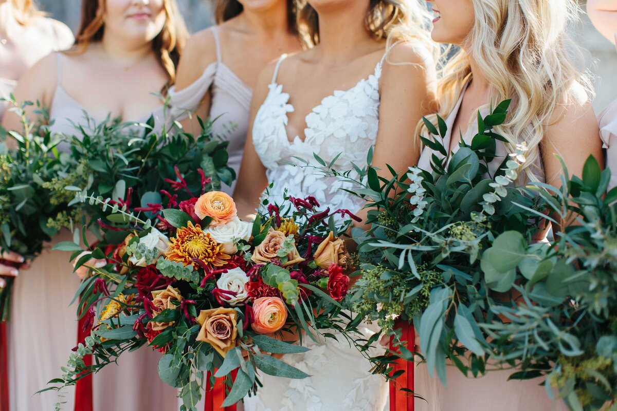 Bride in center surrounded by bridesmaids with the focus on the flower bouquets