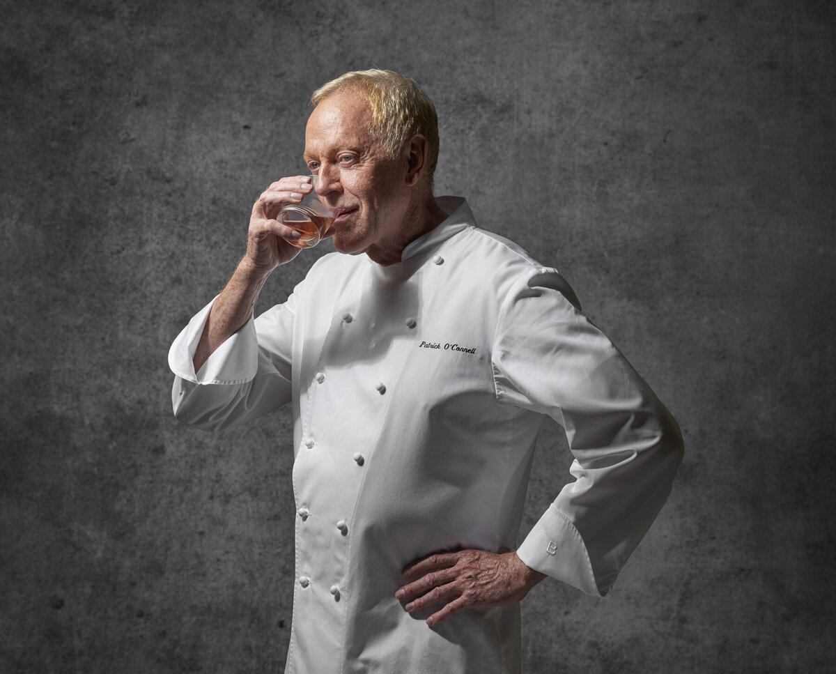 A chef drinking from a glass