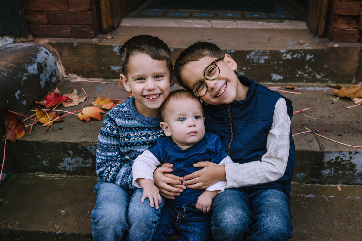Three little boys sitting on stairs in Mexican War Streets. 
