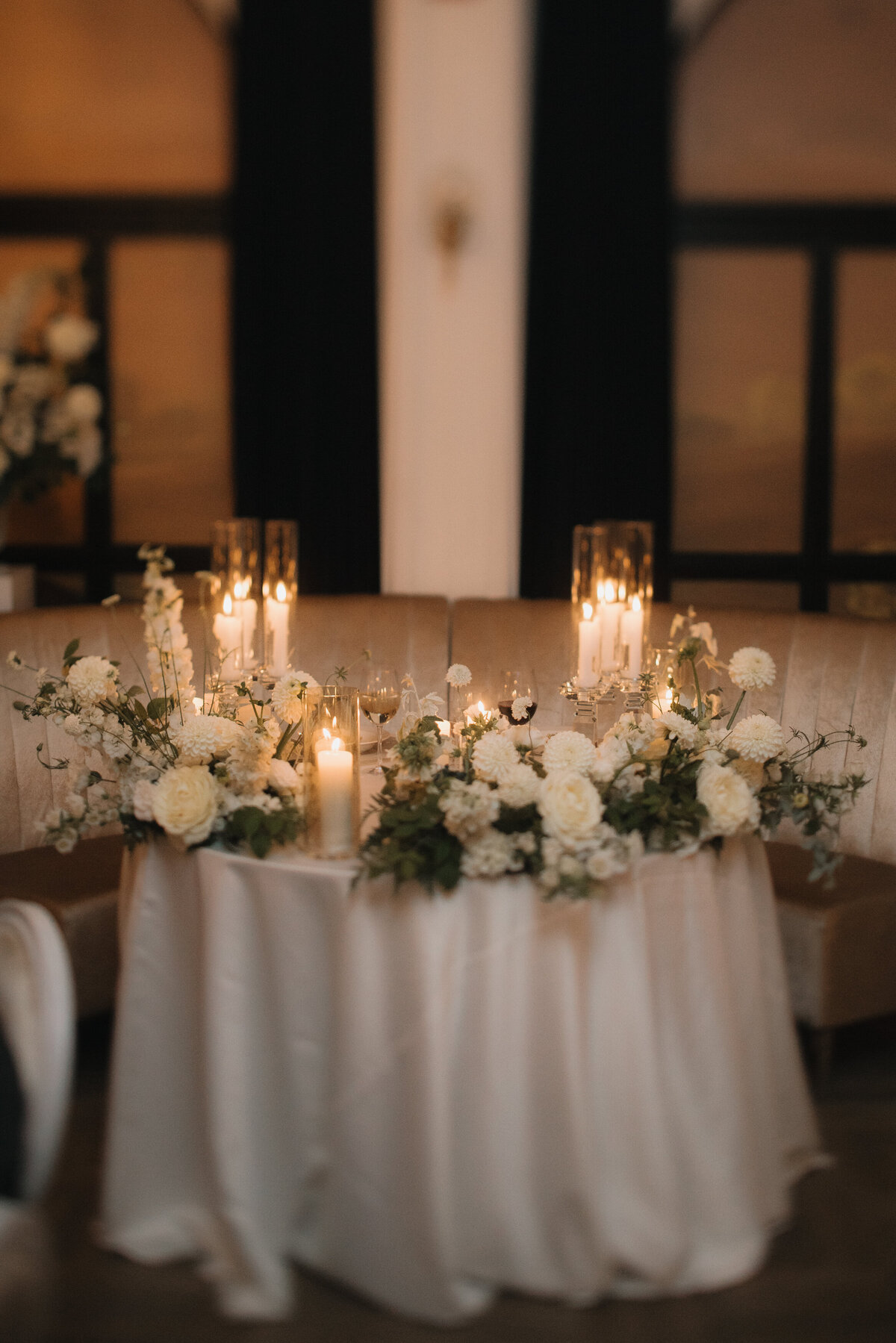 An intimate sweetheart table at the Atwater Club decorated with candles and white flowers.