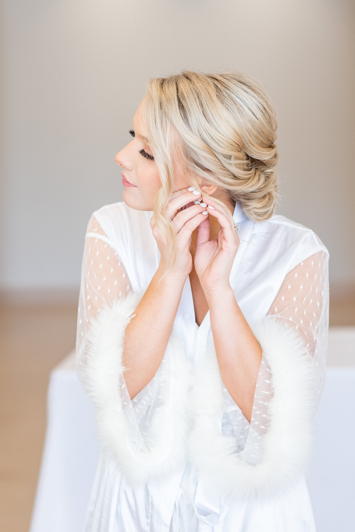 bride putting on earrings