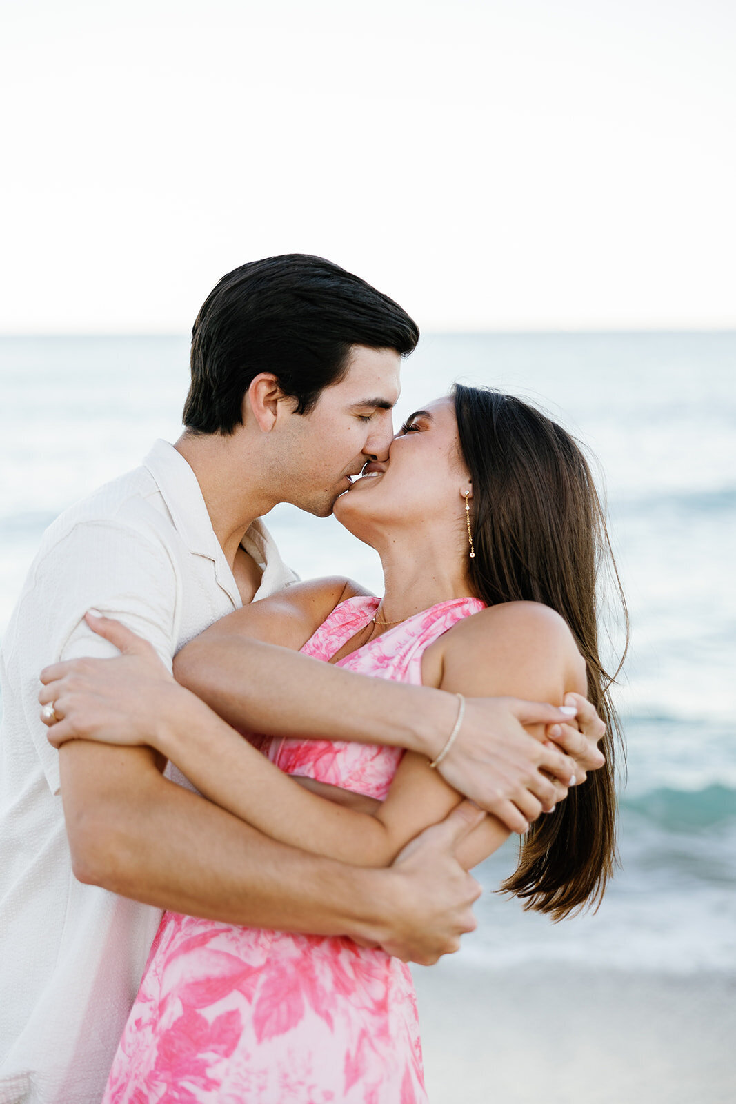 The engaged couple shares a passionate kiss as the ocean breeze surrounds them, capturing their love during their Florida Keys engagement session at Marriott Hotel Fort Lauderdale.