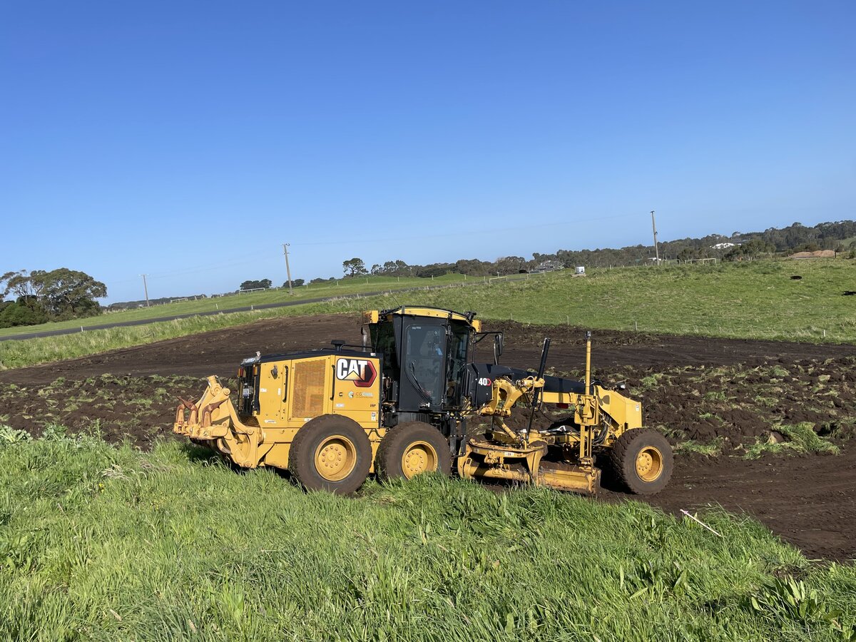 grader removing vegetation for new house site cut and landscaping