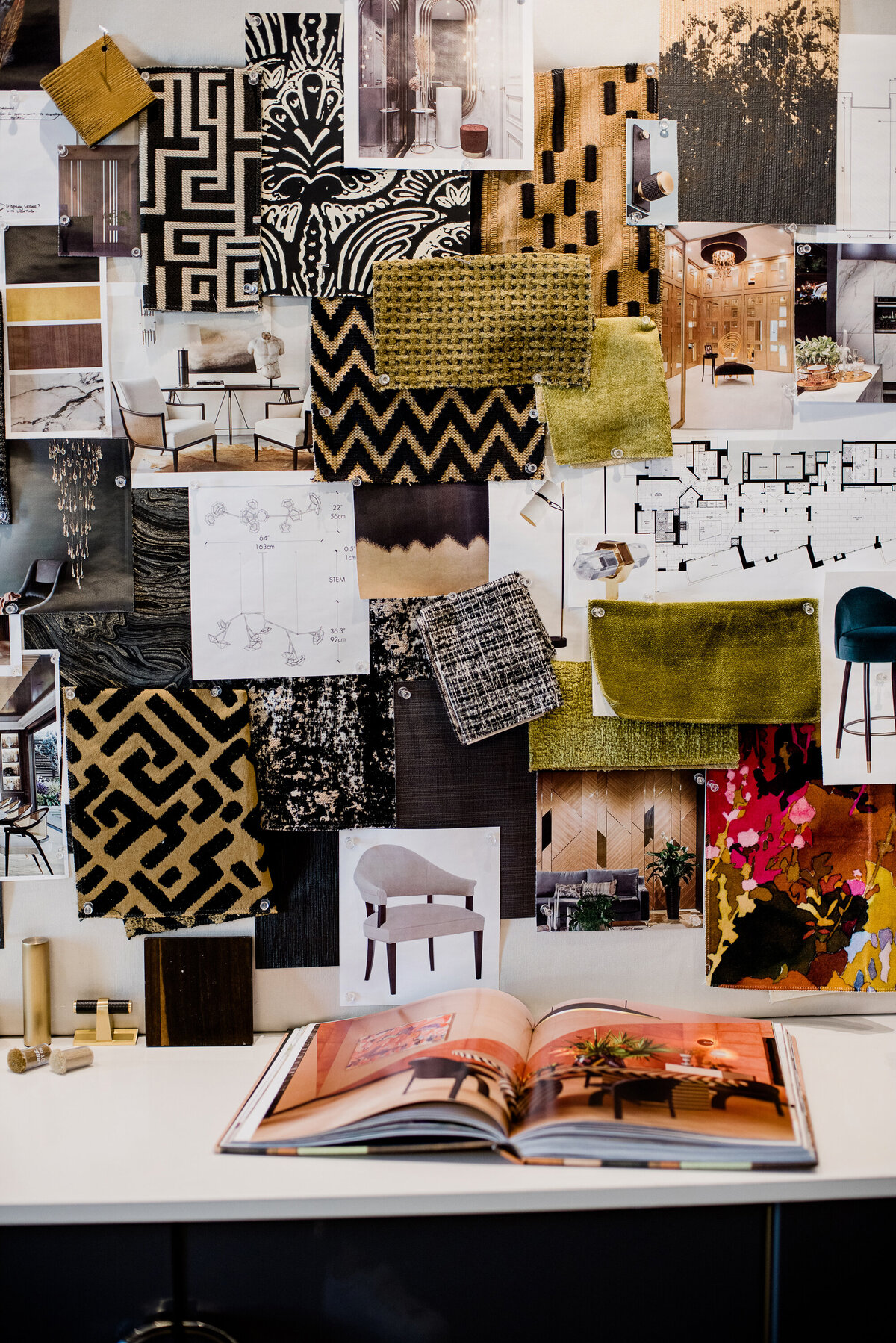 Flat flat photo showing design detail items, everything has a refined feel to it, there are brass fictures, silver handles, bronze textured fabric and wallpaper selections