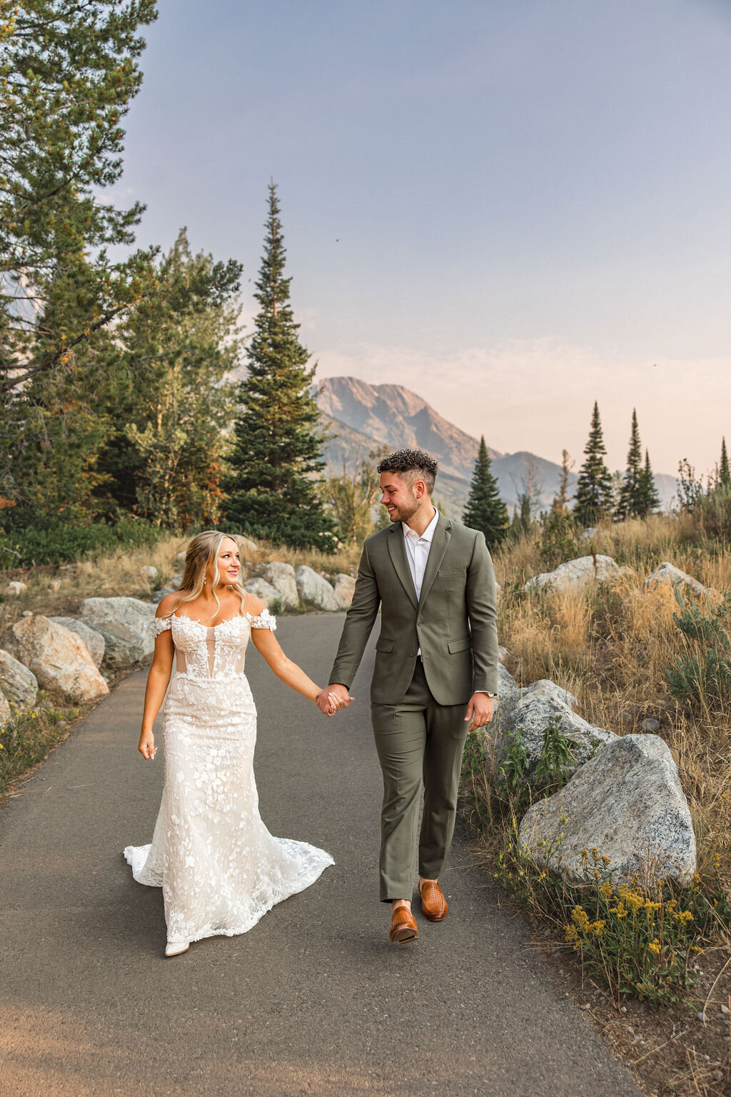 Photo of bride and groom holding hands and walking together.