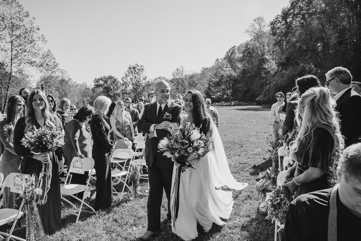 A parent walking their child down the aisle 