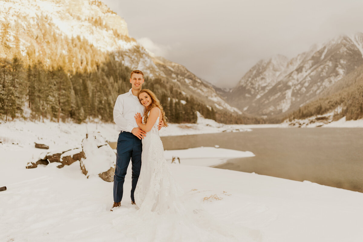 bride and groom posing by lake