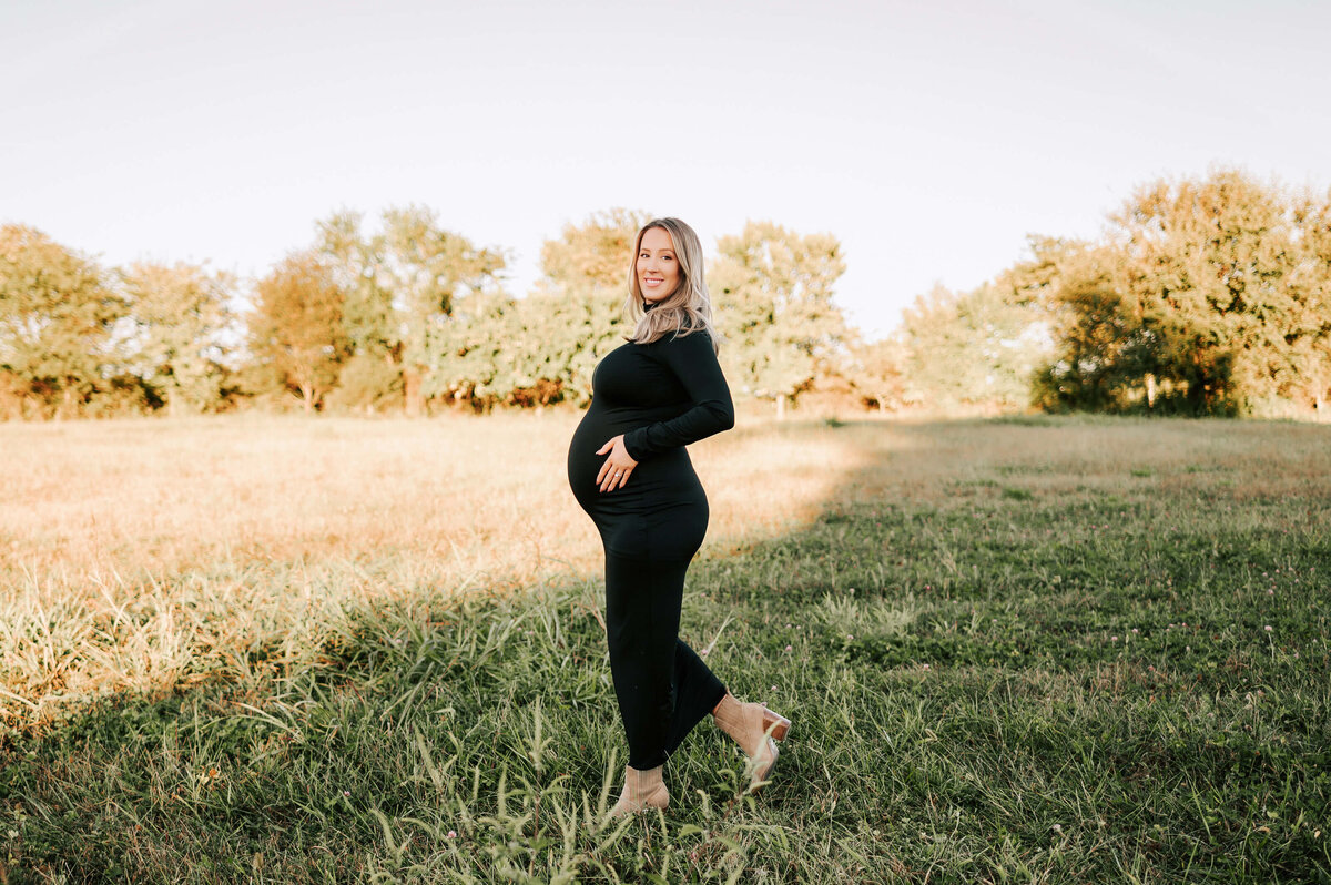 Springfield MO maternity photographer Jessica Kennedy of The XO Photography of mom holding baby bump walking in field