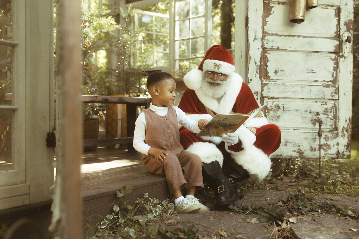 The Black Santa of Atlanta reads a Christmas book to a little boy at Das Hinterhaus in Marietta, GA. 