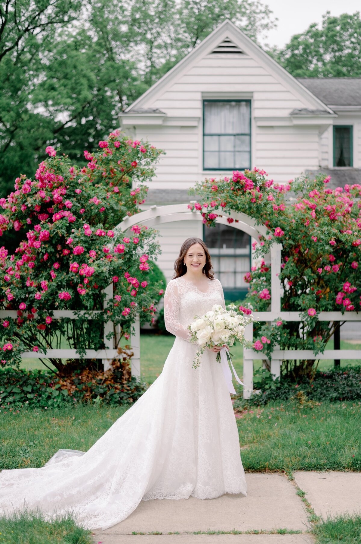a bride posing for photos in front of trees with flowers in bloom