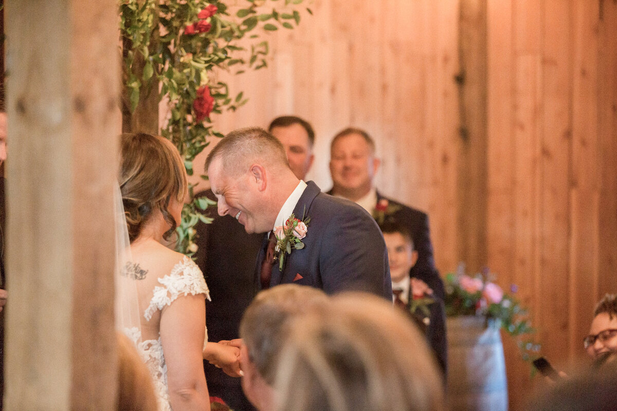 The groom laughs during the wedding ceremony