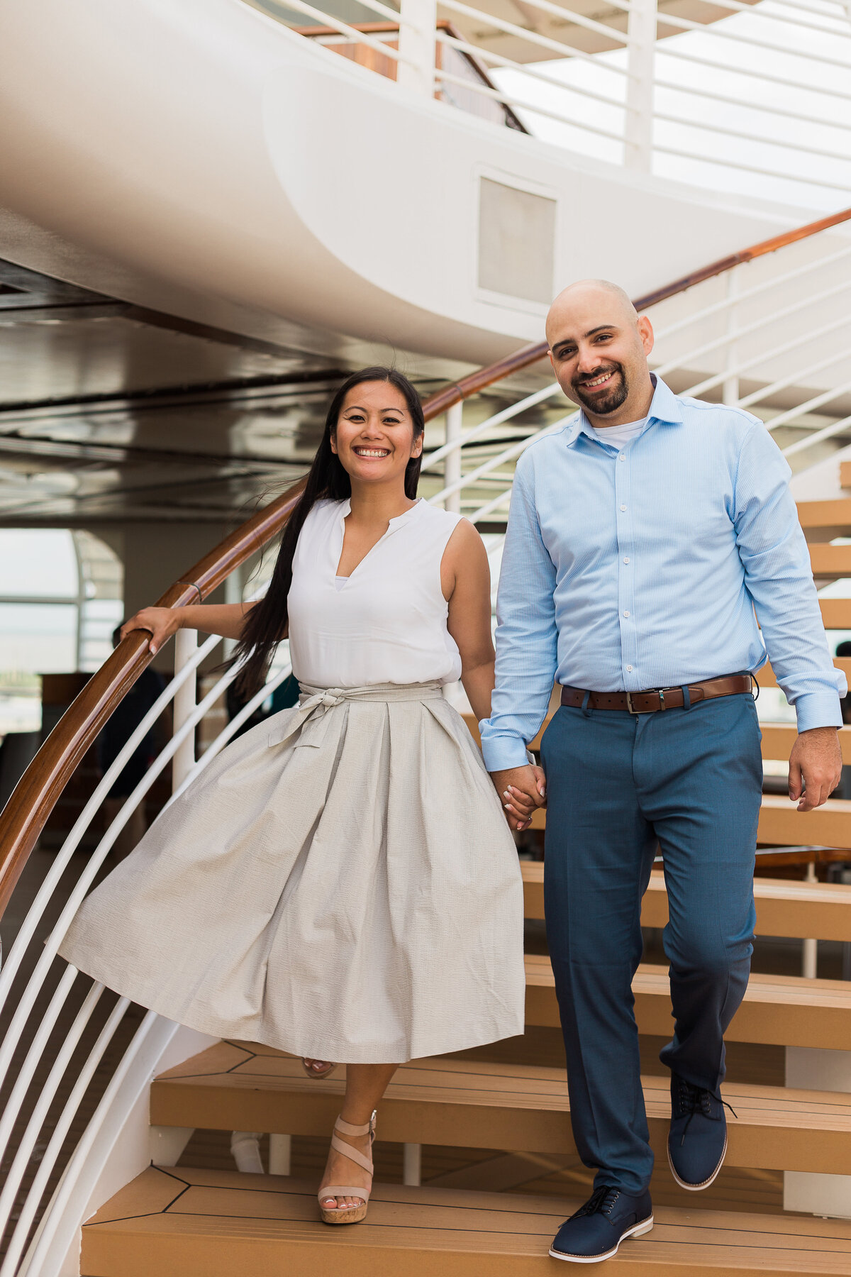 Couple smiling and holding hands walking down stairs at Disney