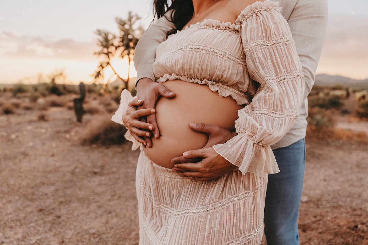 close up of mixed race couple posing for maternity session at lost dutchman state park in arizona for maternity session