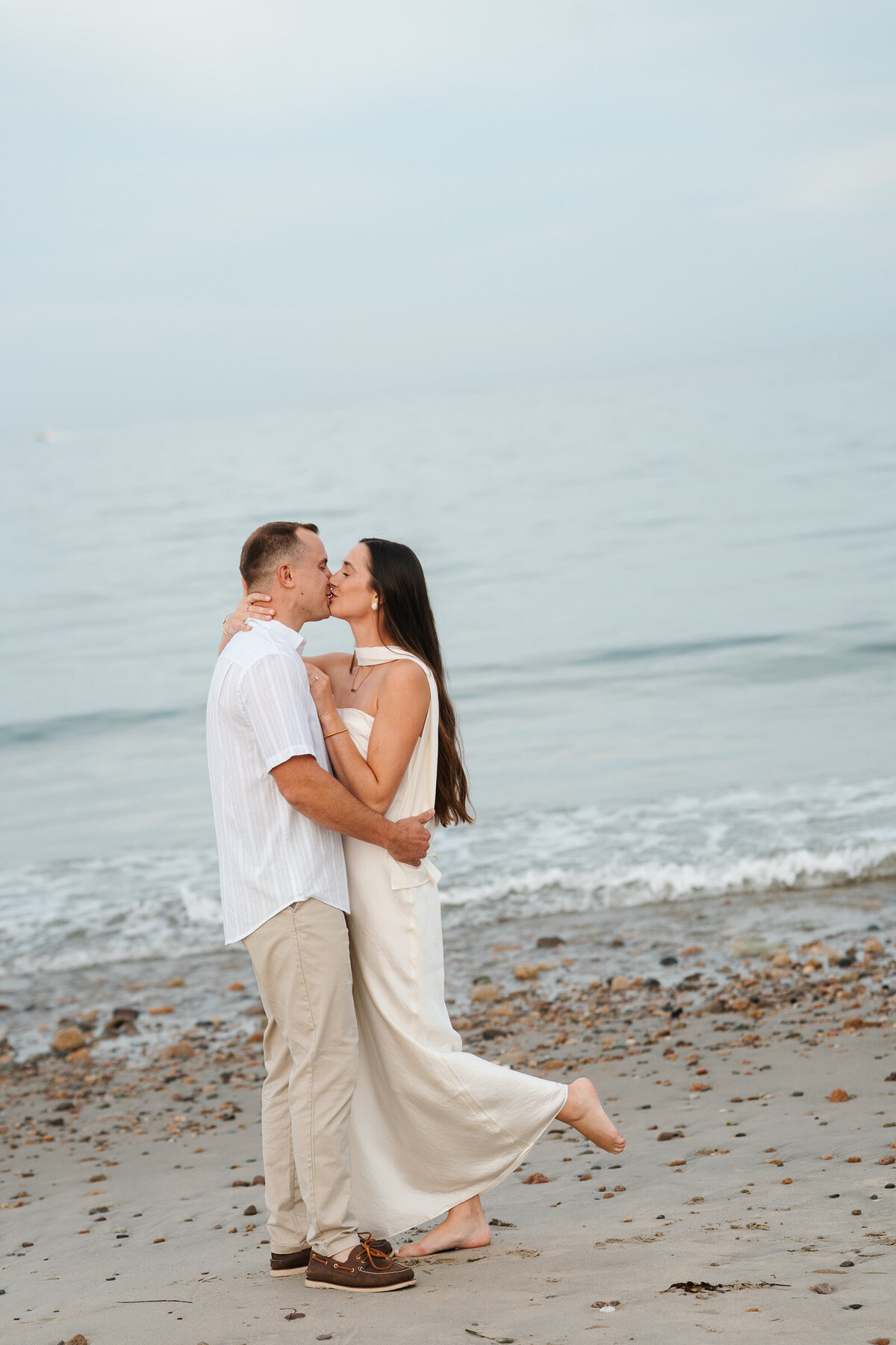 New England beach engagement photos during a sunset coastal session with candid moments.