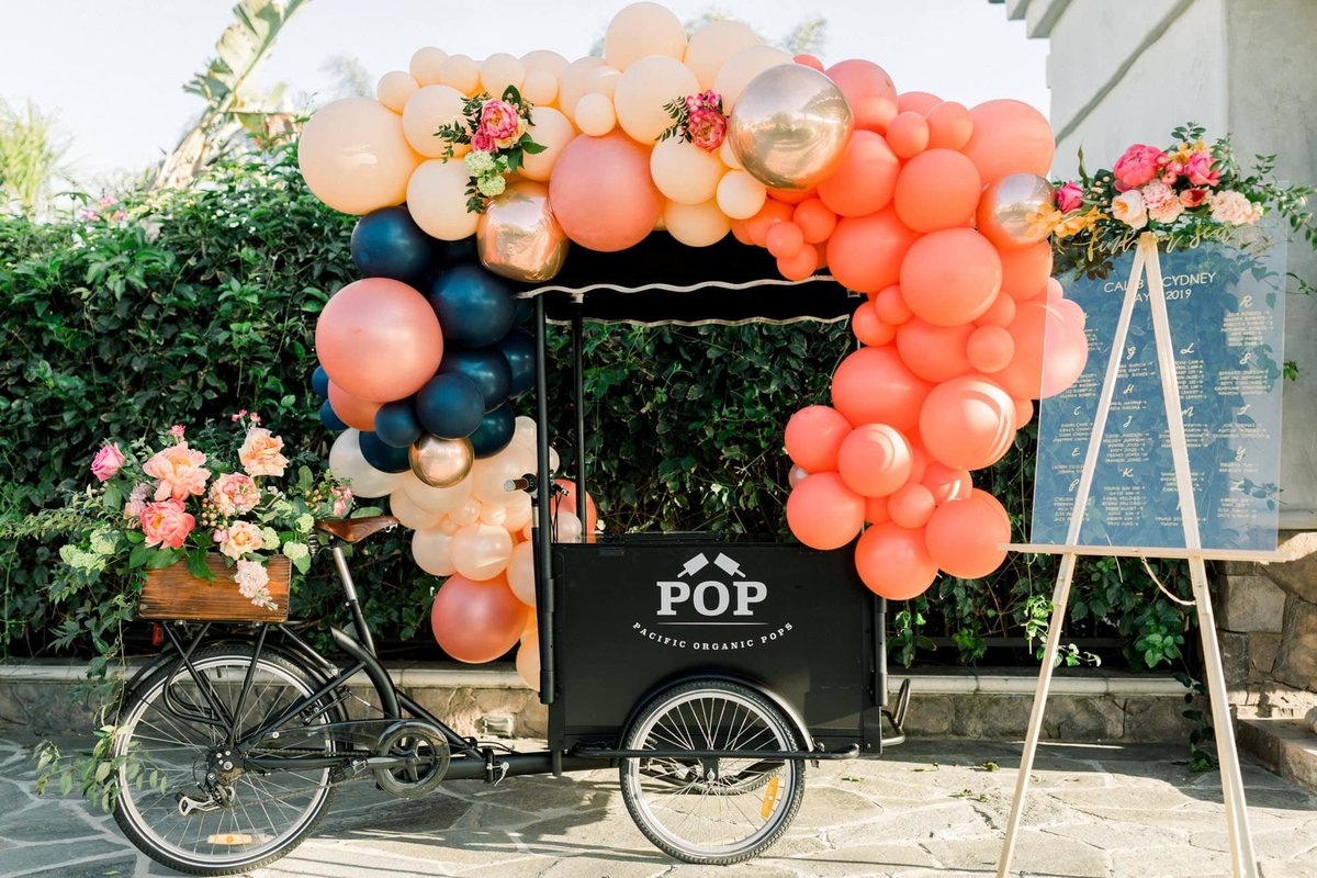 Antique popsicle bike cart decorated with balloons as a wedding decoration