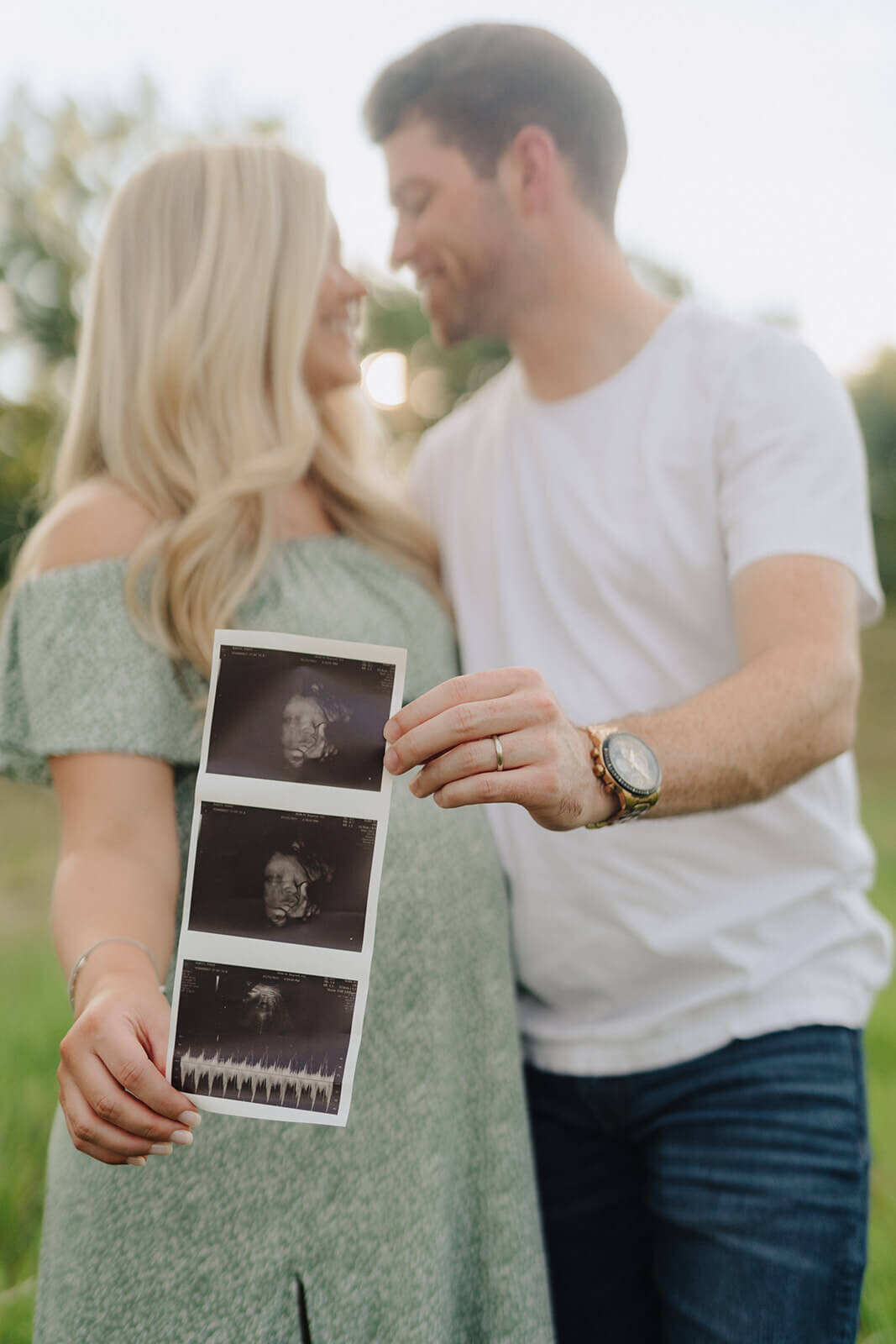 Couple holding baby scan photos for  maternity session in Finger Lakes, New York