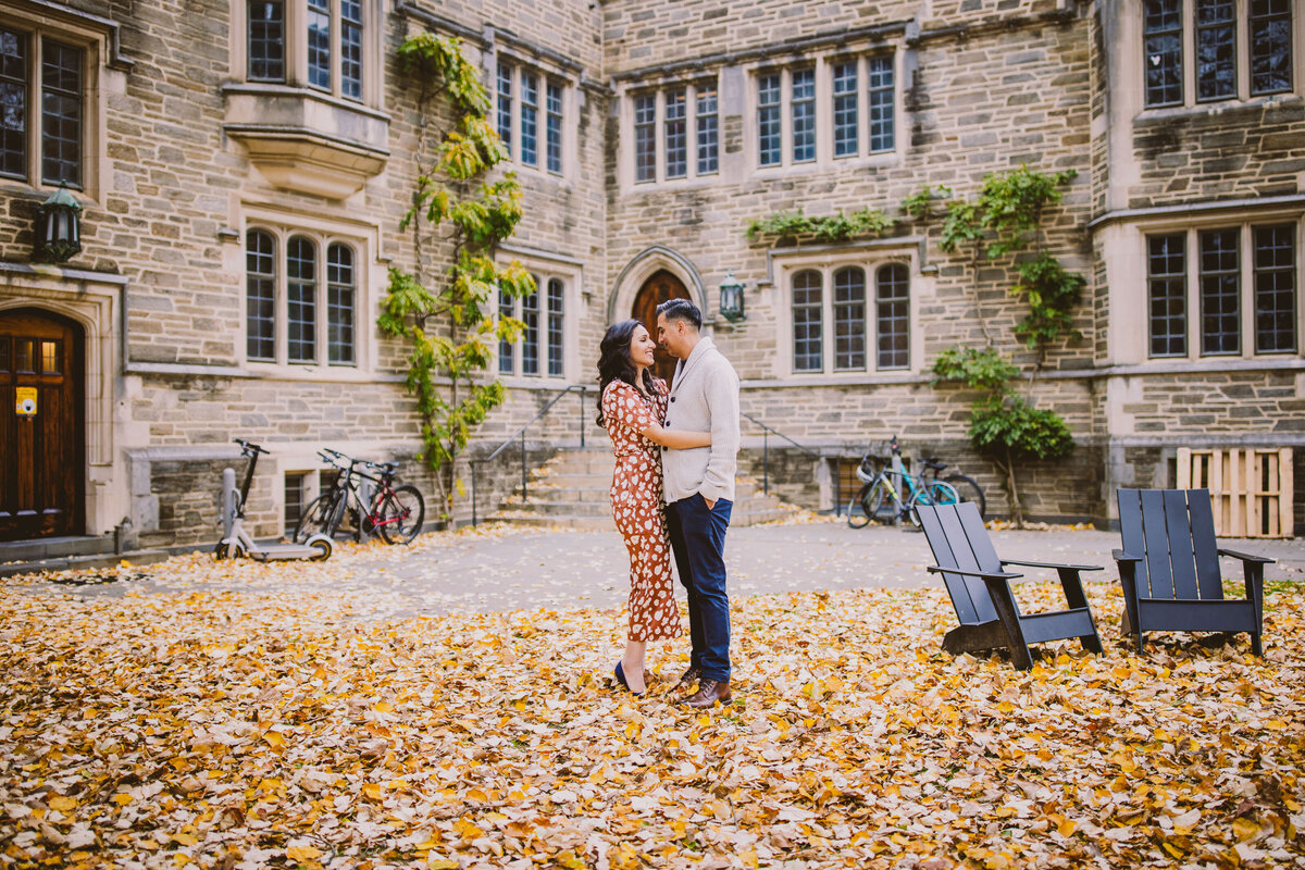A couple looking at each other on top of fall leaves at princeton university in nj