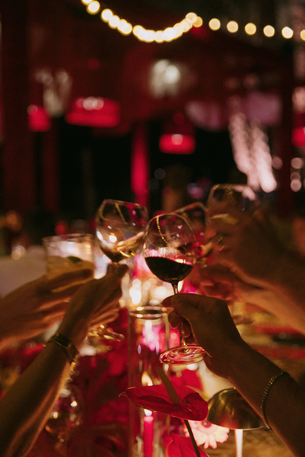 guests cheers wine glasses across a reception table at san diego wedding