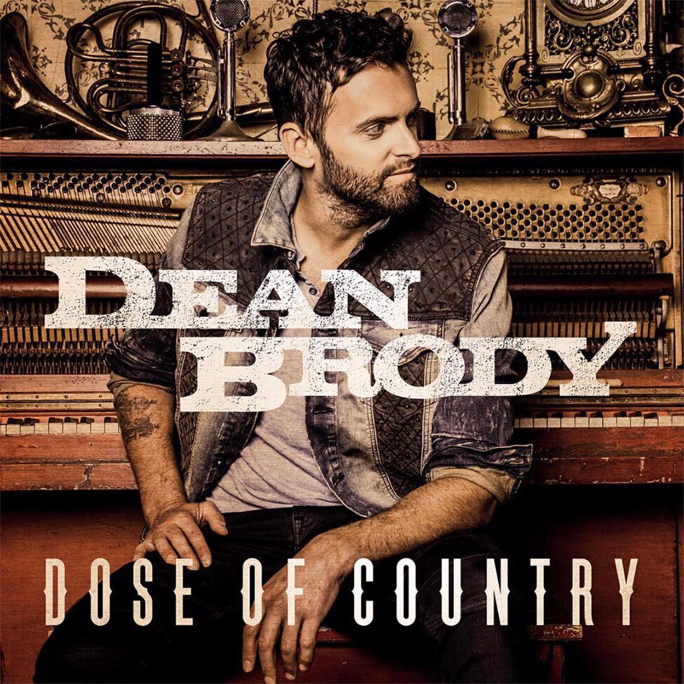 Dean Brody Single Cover Title Dose Of Country sitting on piano bench facing  camera looking off frame