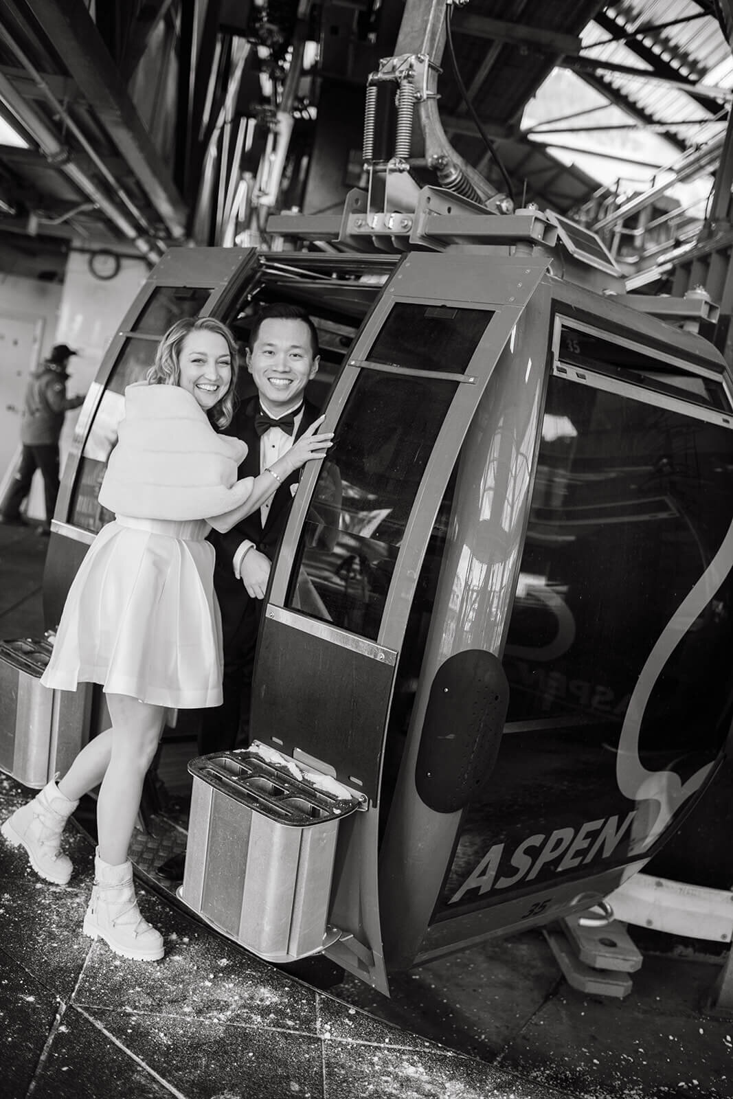 Bride and groom standing outside ski gondola doors at St. Regis Aspen, sharing a romantic moment.