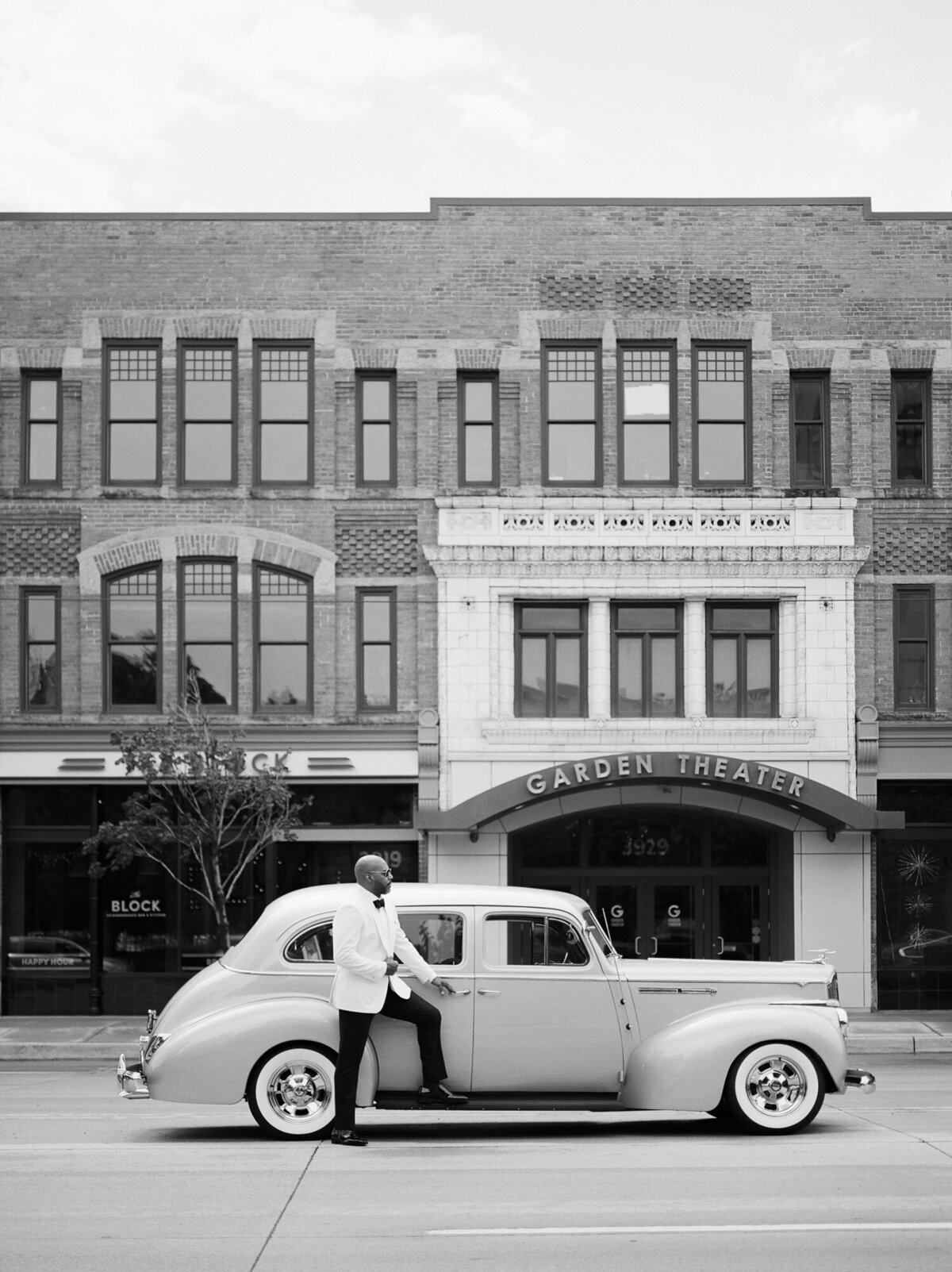 handsome black groom with vintage packard wedding car in Detroit, Michigan by Garden Theater