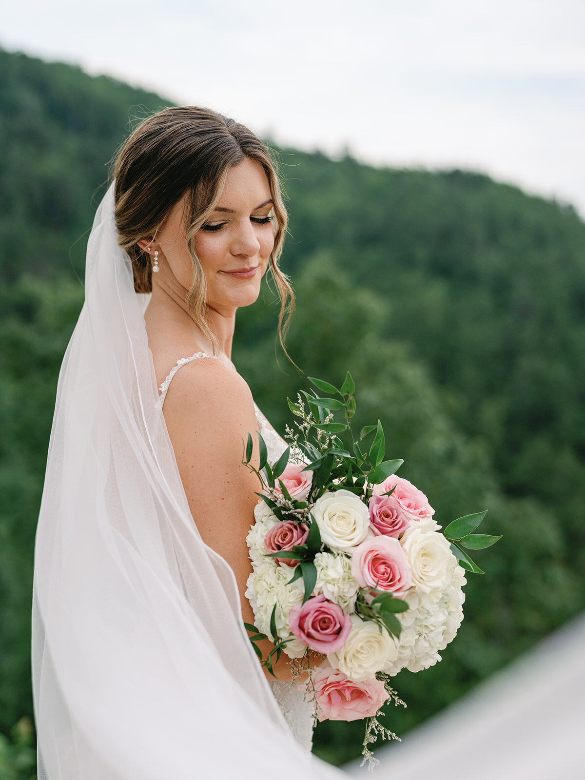 Bride holding a white and blush rose and hydrangea bouquet