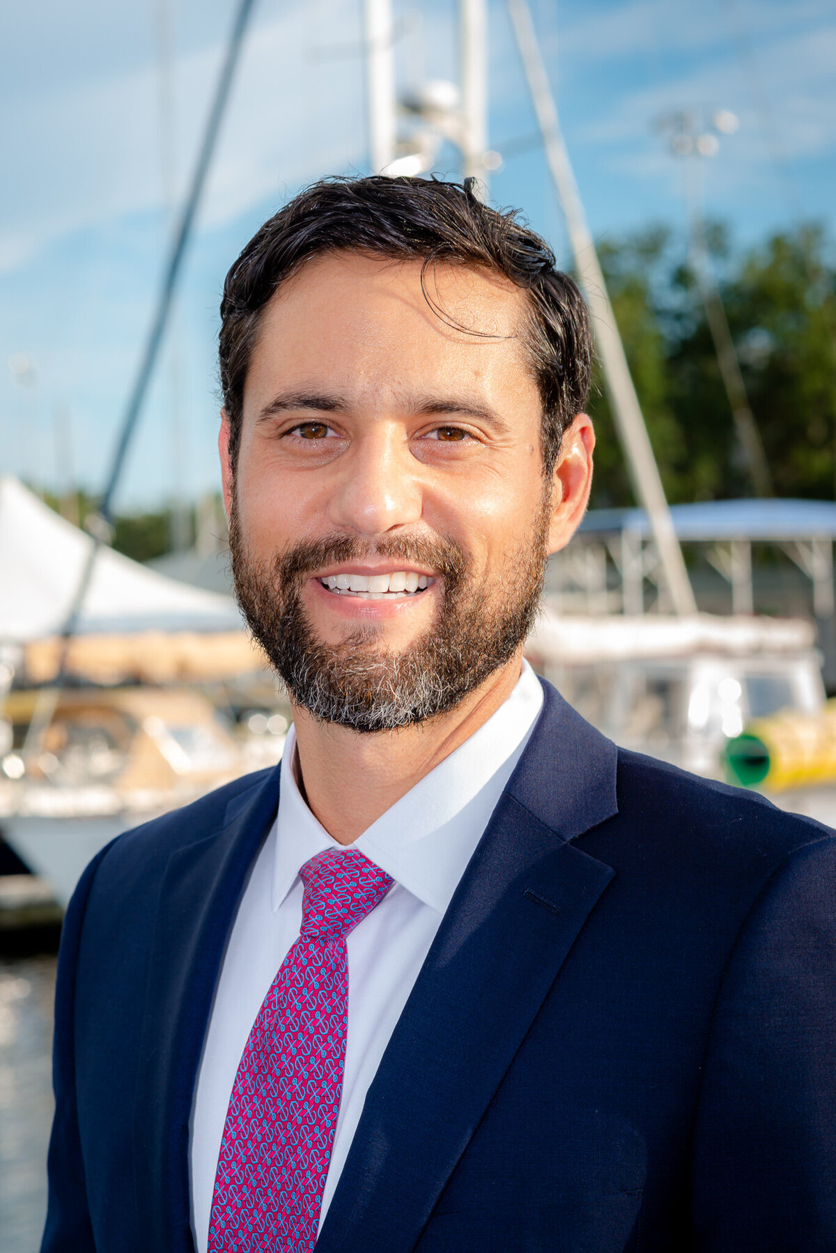 A Lawyer poses in front of sailboats for his headshots.