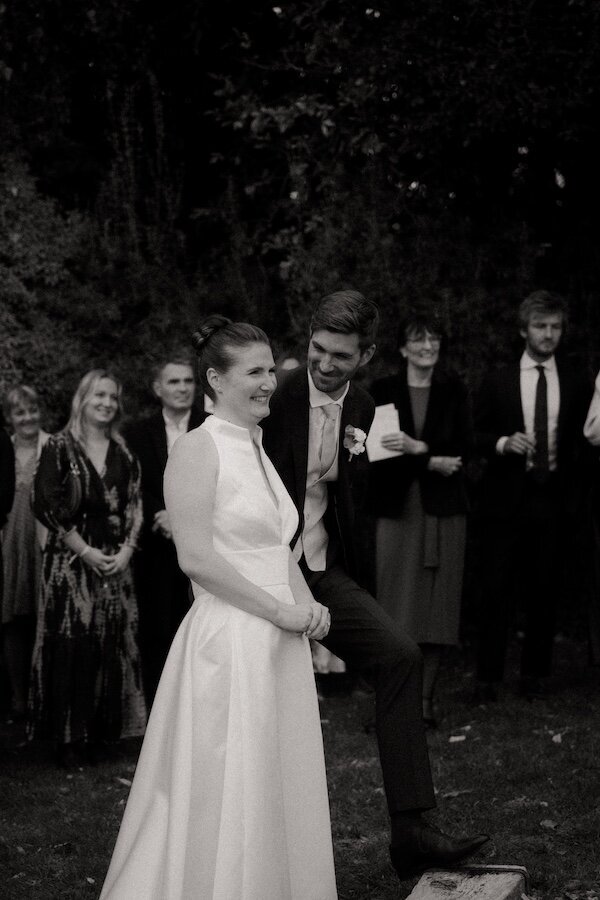 Les mariés rient sous les salutations des invités pendant une animation. Moment de complicité immortalisé par Kamescop, vidéaste et photographe de mariage vintage.
