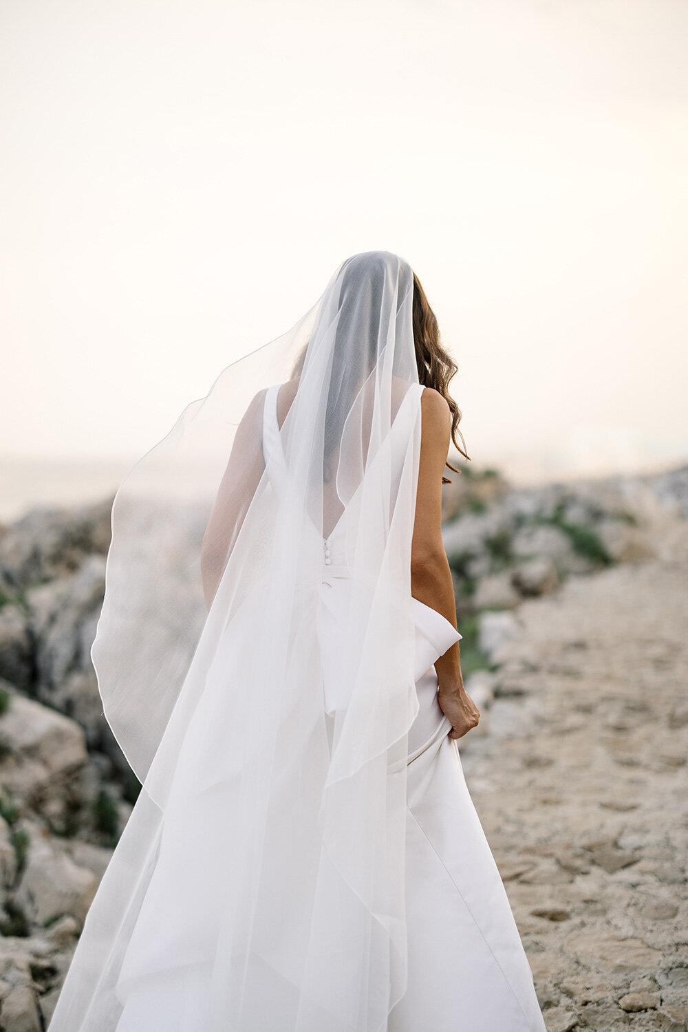 bride walking cliffs of cap ferrat on her wedding day