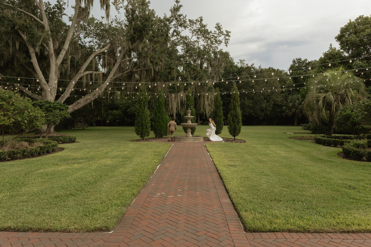Romantic backyard wedding at The Palm Mansion in Umatilla, Florida with lush palm trees and floral arch