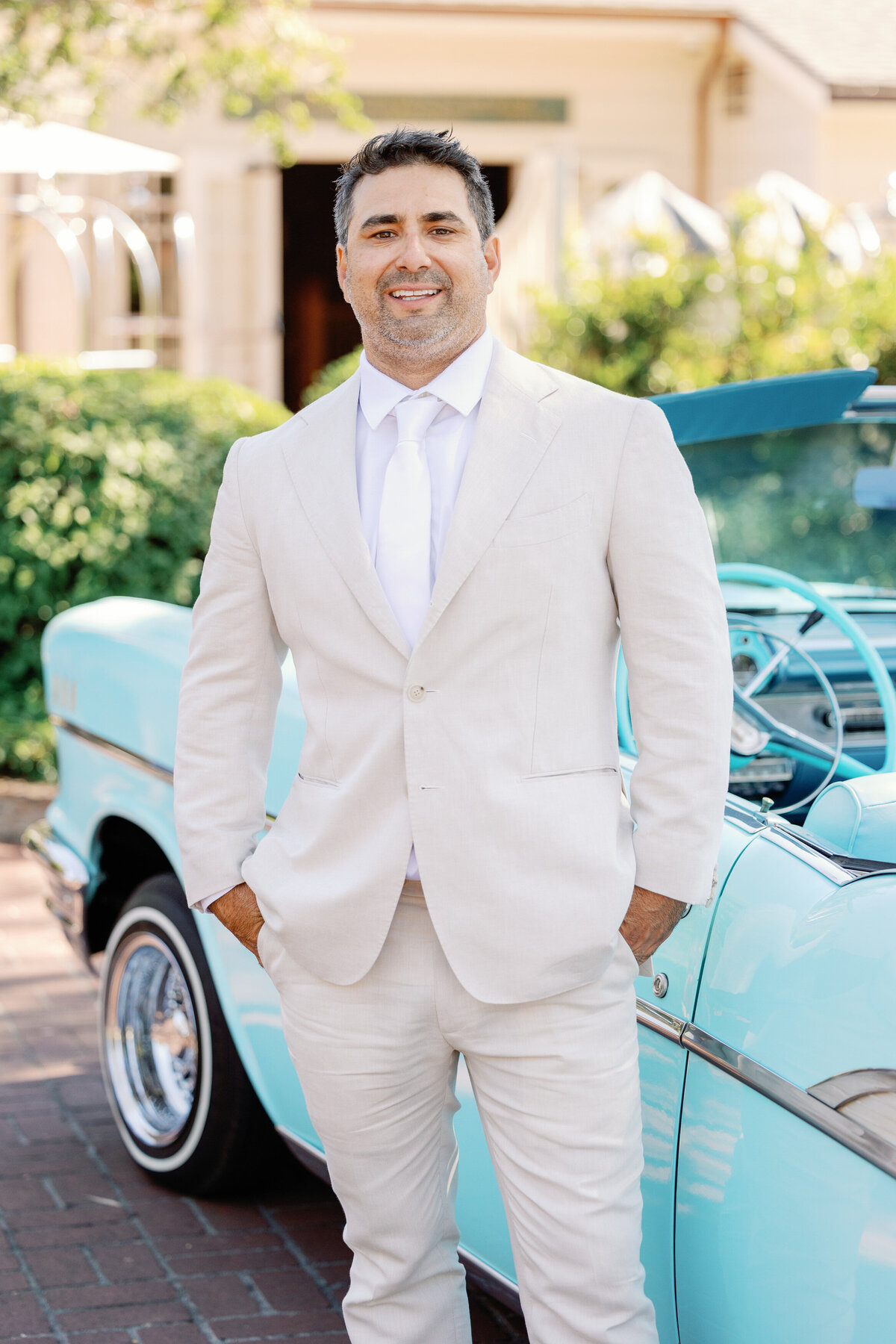 Groom wearing a cream tuxedo and white tie