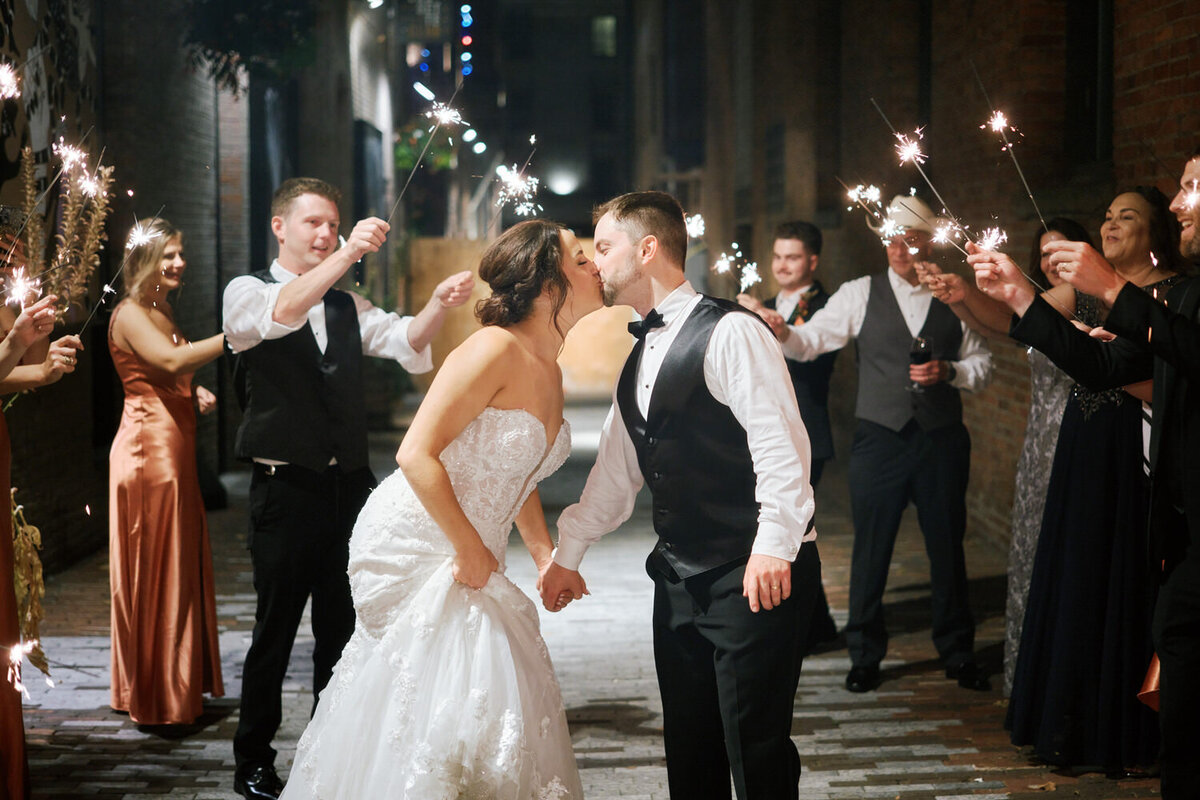 Bride and groom kiss during the sparkler exit