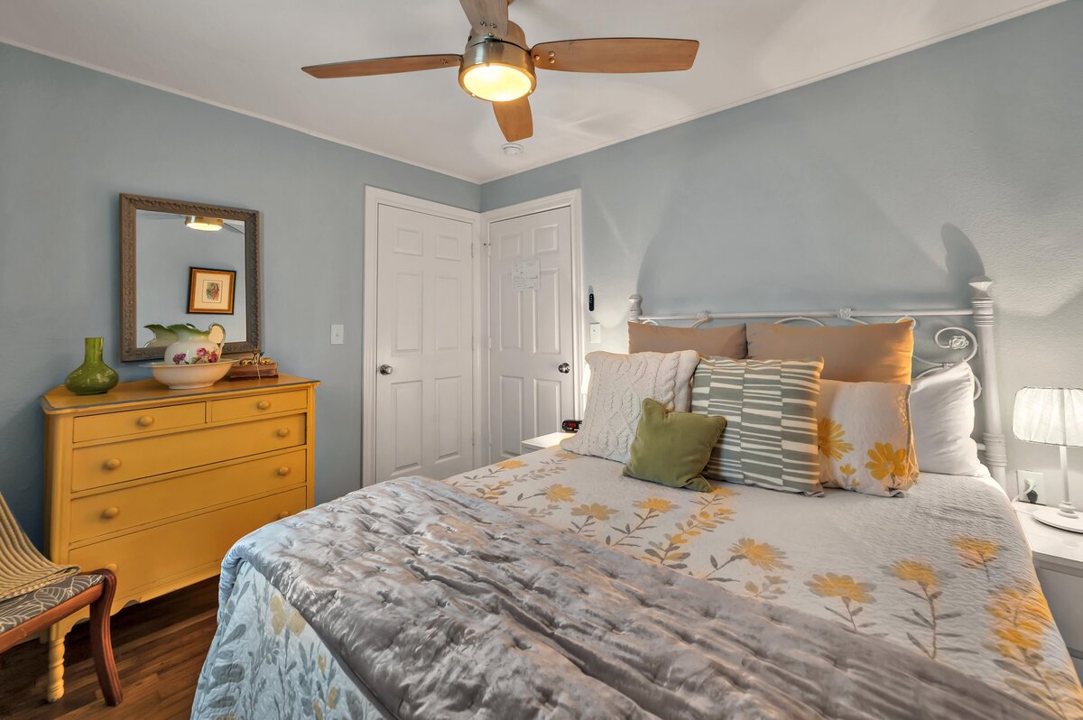Bedroom with beautiful bedding in this three-bedroom, two-bathroom vacation rental house with free Wifi, fully equipped kitchen, office space, and room for six in downtown Waco, TX.