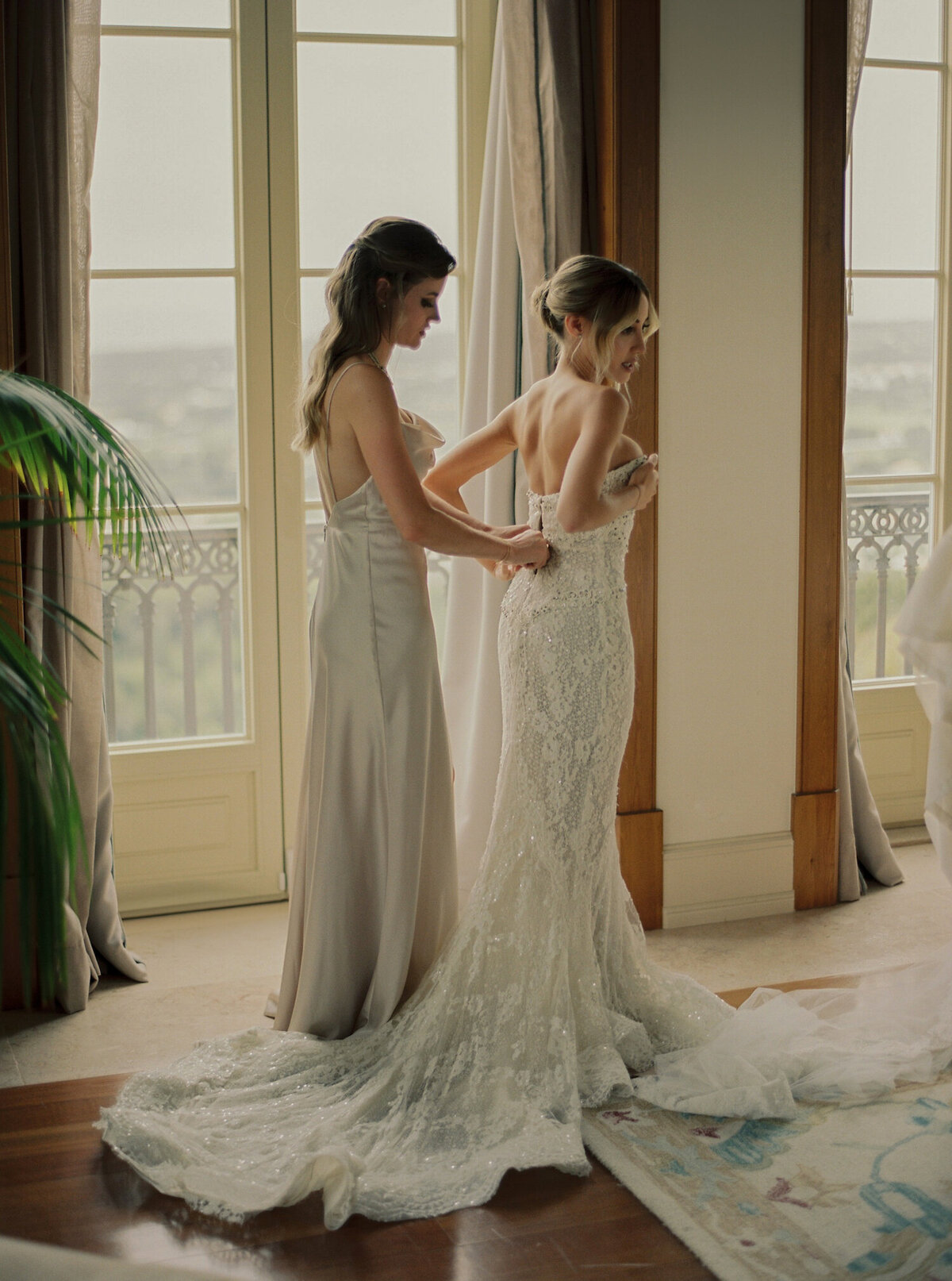 The bride is putting her dress on for her Quinta da Bellavista destination wedding