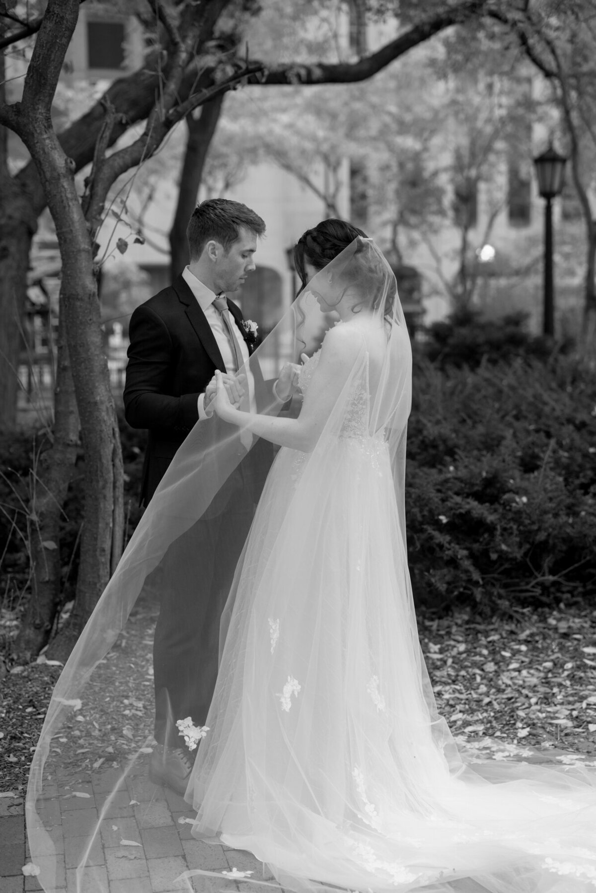 A groom’s emotional reaction as he sees his bride for the first time, captured in a timeless black and white wedding photo.