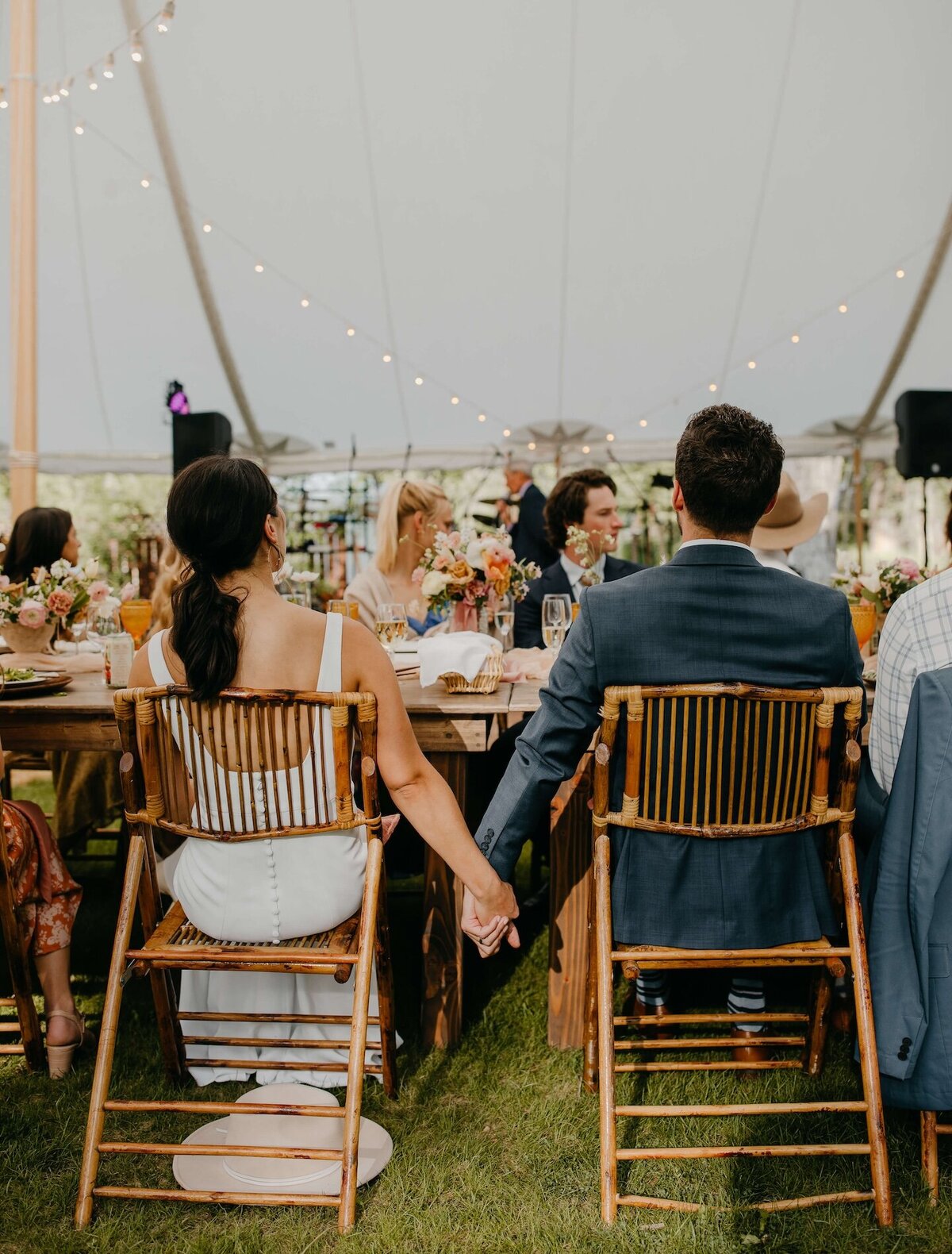 bride-groom-at-reception-holding-hands-bentwood-inn-wy