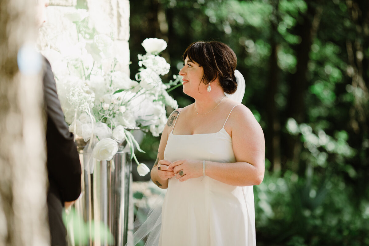 Bride looking at florals at Umlauf Sculpture Garden wedding, Austin