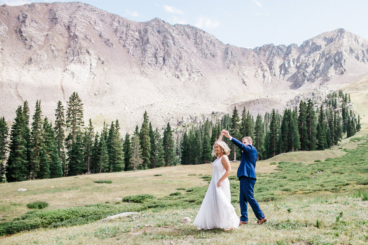 Rocky mountain wedding bride and groom dance in a mountain meadow