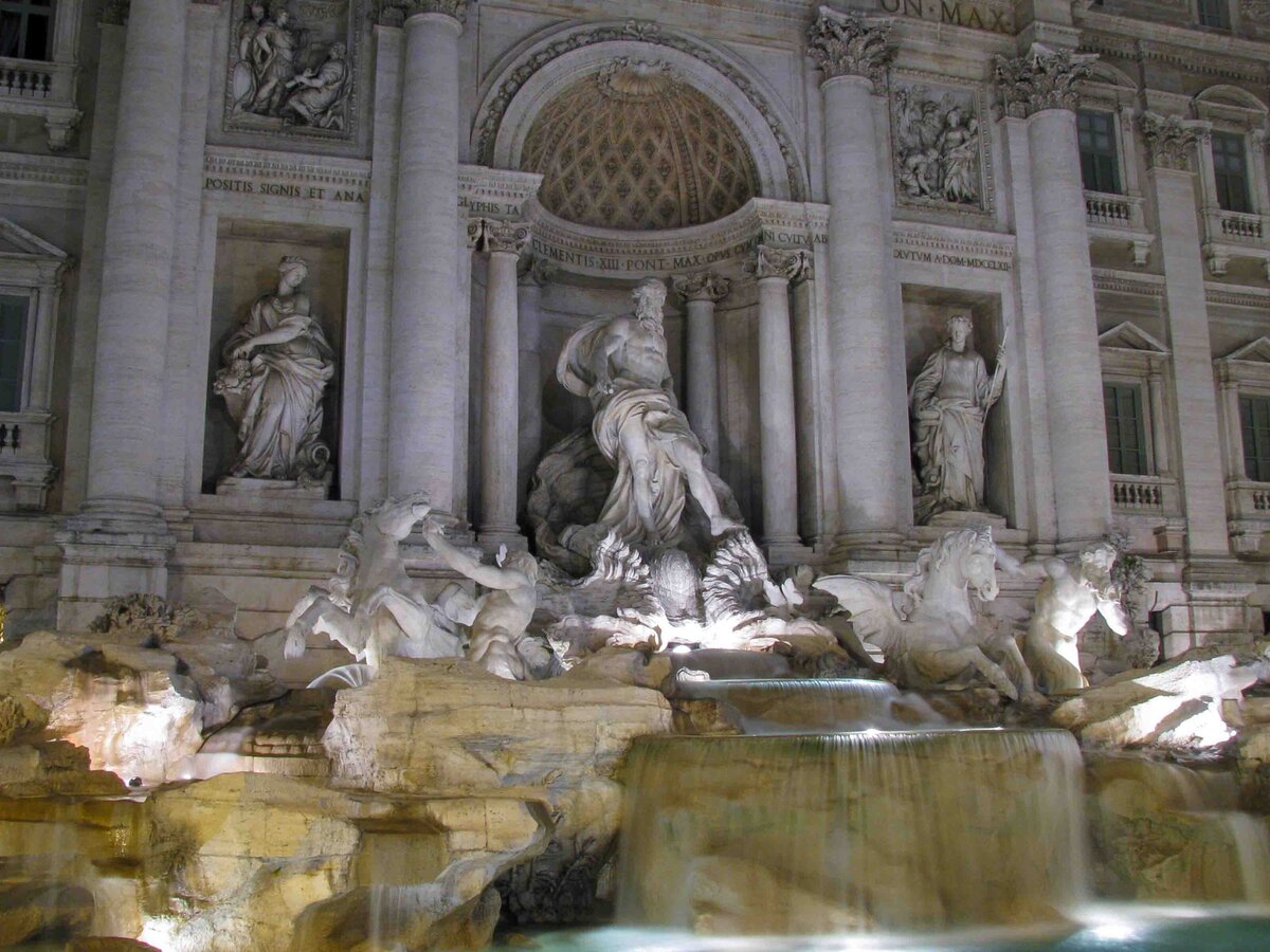 Illuminated sculptures of Oceanus, Tritons, and sea horses at the Trevi Fountain at night in Rome, Italy ©Stephanie Dosch | theViatrix Luxury Travel