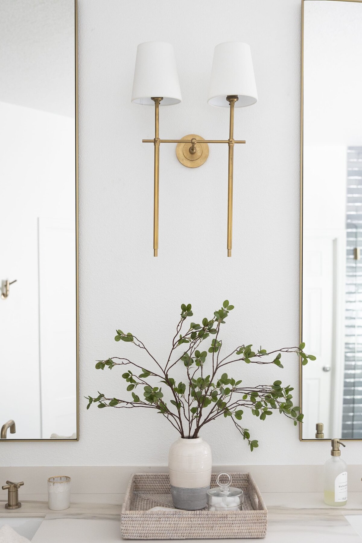 dewine design orlando interior designer contemporary coastal primary bathroom gold light fixture and plant on counter