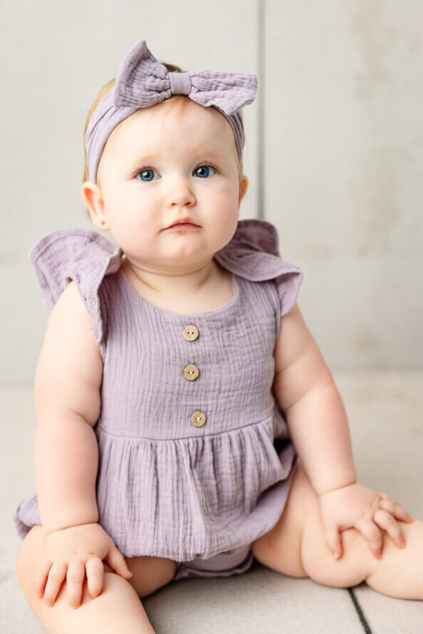 Cute baby poses for camera in studio.