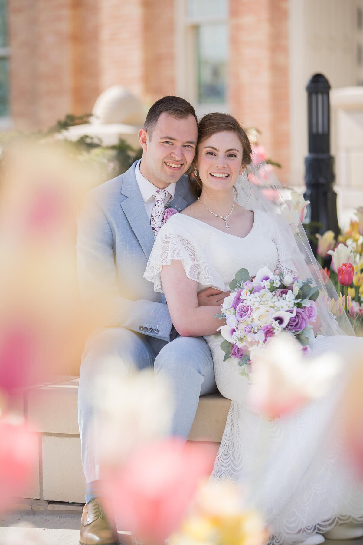 a wedding couple sitting in a tulip garden